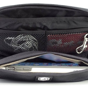May include: Black zippered travel case with multiple compartments and a mesh pocket. The case is open to reveal a tablet computer inside.