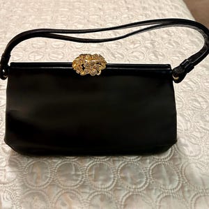 Bolso de mano Koret negro de los años 50 con cierre de joya dorada.