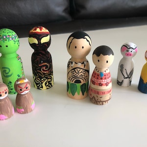 May include: A collection of hand-painted wooden peg dolls. The dolls feature various designs, including floral patterns, tribal motifs, and animal-inspired characters. The color palette includes green, brown, red, yellow, and blue.