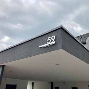Puede incluir: Una casa moderna gris con el n&uacute;mero 59 blanco y el texto "CESTA NA HUDO" en el exterior.