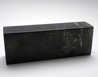 May include: A dark green rectangular block of wood with a swirling pattern of lighter green and white.