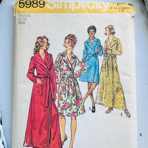 May include: Vintage Simplicity sewing pattern 5989 for Misses' robes and dresses. The pattern features illustrations of four different robe and dress designs in various colors and patterns. The pattern size is Medium 12-14.