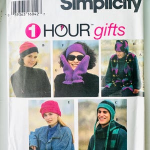 May include: A Simplicity 9224 sewing pattern envelope for 1 Hour Gifts. The white paper packaging features text and five photographs displaying various handmade accessories including knit hats, a headband, mittens, and a scarf in multiple colours.