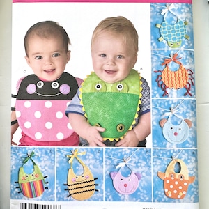 May include: Simplicity sewing pattern 2468 for baby bibs in one size. The package features illustrations of various animal-themed bibs including a ladybug, alligator, bee, and cat designs. The front displays two infants wearing the bibs.