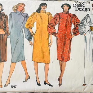 May include: A Vogue's Basic Design sewing pattern envelope 1017 featuring illustrations of five different dress styles. The designs include various necklines, long sleeves, and waist details in brown, blue, yellow, red floral, and white colorways.