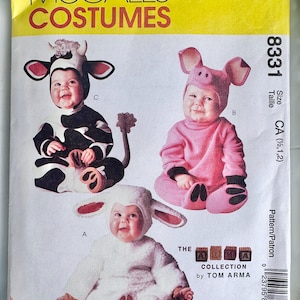 May include: McCall's Costumes pattern 8331 for infants, featuring three animal designs: a black and white cow, a pink pig, and a white lamb. The envelope displays the Tom Arma collection branding and includes size information for 1/2, 1, and 2.