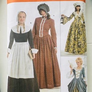 May include: Simplicity sewing pattern 3723, size R5 14-22, featuring illustrations of four historical-style dresses. Designs include a black and white outfit, a brown floral dress with a bonnet, a yellow floral gown, and a blue and gold dress.