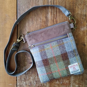 Sac à bandoulière en tweed Harris et toile cirée marron avec poche zippée sur le devant. Panneau MacLeod en tweed patiné en bleu, vert, marron