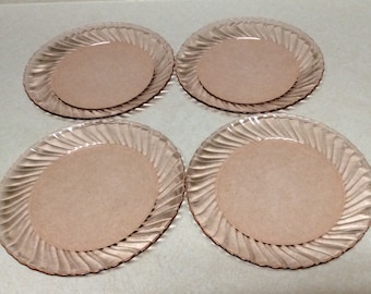 Puede incluir: Juego de cuatro platos de cena de vidrio rosa con diseño de espiral.