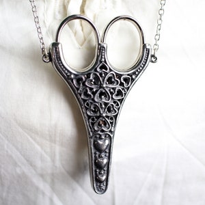 Piccole forbici da ricamo a forma di cuori in un portaforbici stile chatelaine vittoriano