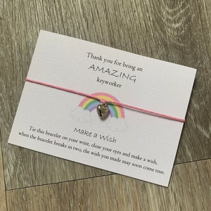 May include: A pink and white rainbow charm bracelet with a silver heart charm. The card reads "Thank you for being an AMAZING keyworker. Make a Wish. Tie this bracelet on your wrist, close your eyes and make a wish, when the bracelet breaks in two, the wish you made may soon come true."