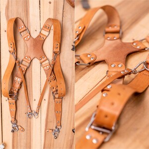 Pu&ograve; includere: Un set di bretelle in pelle marrone chiaro con finiture in metallo argentato. Le bretelle hanno cinghie regolabili e un design a schiena incrociata. La pelle &egrave; di colore marrone naturale e l'hardware in metallo include clip e fibbie.