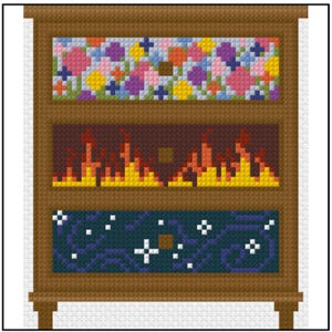 Op de afbeelding: Een bruine houten ladekast met drie lades, elk voorzien van een verschillend pixel art patroon. De bovenste lade toont een kleurrijk bloemmotief, de middelste lade een vlammenontwerp en de onderste lade een donkerblauwe sterrenhemel.