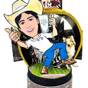 K&ouml;nnte beinhalten: Ein 3D-Papieraufsteller mit einer Karikatur einer Person in Cowboyhut, wei&szlig;em Polohemd und blauer Jeans, die einen Krug h&auml;lt. Das Display zeigt einen Collie-Hund, ein Footballfeld-Motiv sowie den Text Kyle Field und Happy 21st Birthday.