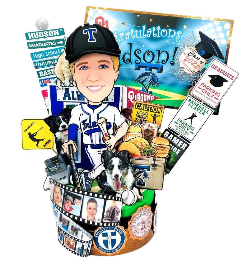 K&ouml;nnte beinhalten: Ein individueller Tortenaufleger mit einem Cartoon-Baseballspieler in blau-wei&szlig;em Trikot und Kappe, umgeben von Miniaturschildern, einem Hund, Lebensmitteln und einem Filmstreifen mit Fotos. Im Hintergrund ein Schild mit der Aufschrift Congratulations Hudson!