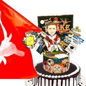 K&ouml;nnte beinhalten: Ein runder Kuchen mit wei&szlig;er Glasur und dunklen Schokoladentropfen, gekr&ouml;nt von einer Karikatur eines Absolventen in rot-wei&szlig;er Uniform, einer gro&szlig;en roten Flagge mit wei&szlig;em Longhorn-Logo und verschiedenen Schildern wie Class of 2020 und Travel Where to Next.
