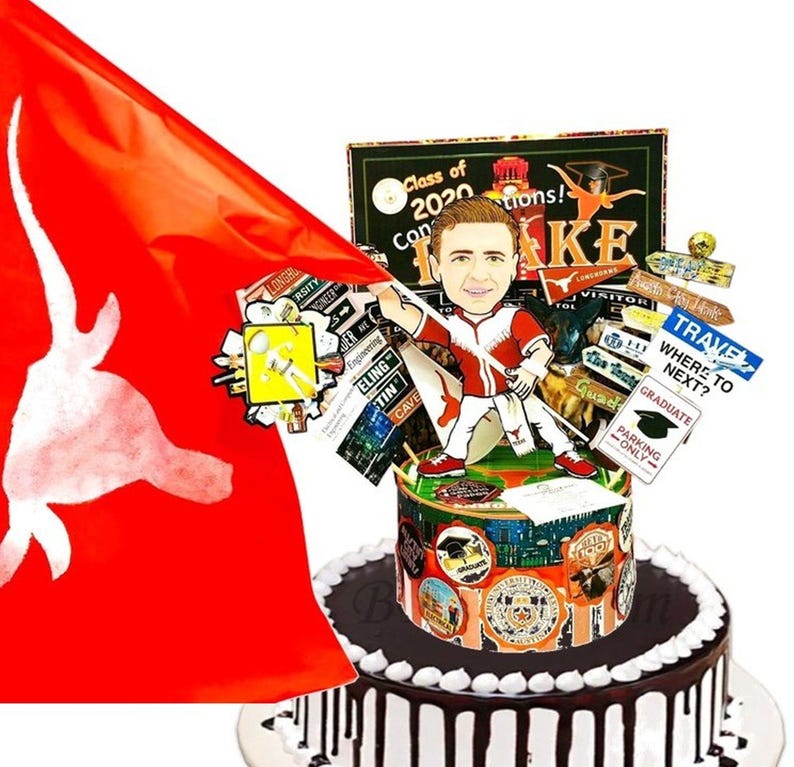K&ouml;nnte beinhalten: Ein runder Kuchen mit wei&szlig;er Glasur und dunklen Schokoladentropfen, gekr&ouml;nt von einer Karikatur eines Absolventen in rot-wei&szlig;er Uniform, einer gro&szlig;en roten Flagge mit wei&szlig;em Longhorn-Logo und verschiedenen Schildern wie Class of 2020 und Travel Where to Next.