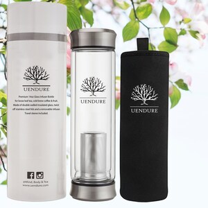 May include: A white insulated travel mug with a black tree logo and the text "UENDURE" on the side. The mug is next to a clear glass water bottle with a stainless steel lid and a removable infuser. The bottle also has a black tree logo and the text "UENDURE" on the side. The bottle is next to a black travel sleeve with a black tree logo and the text "UENDURE" on the side.