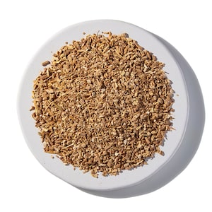May include: A white ceramic plate filled with dried, light brown, and tan coloured root pieces.