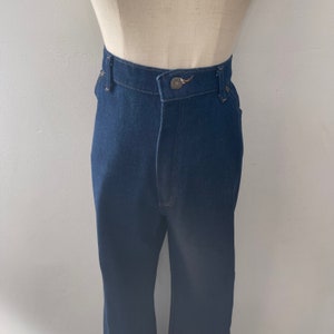 May include: A pair of dark blue denim jeans with a high waist and a straight leg.