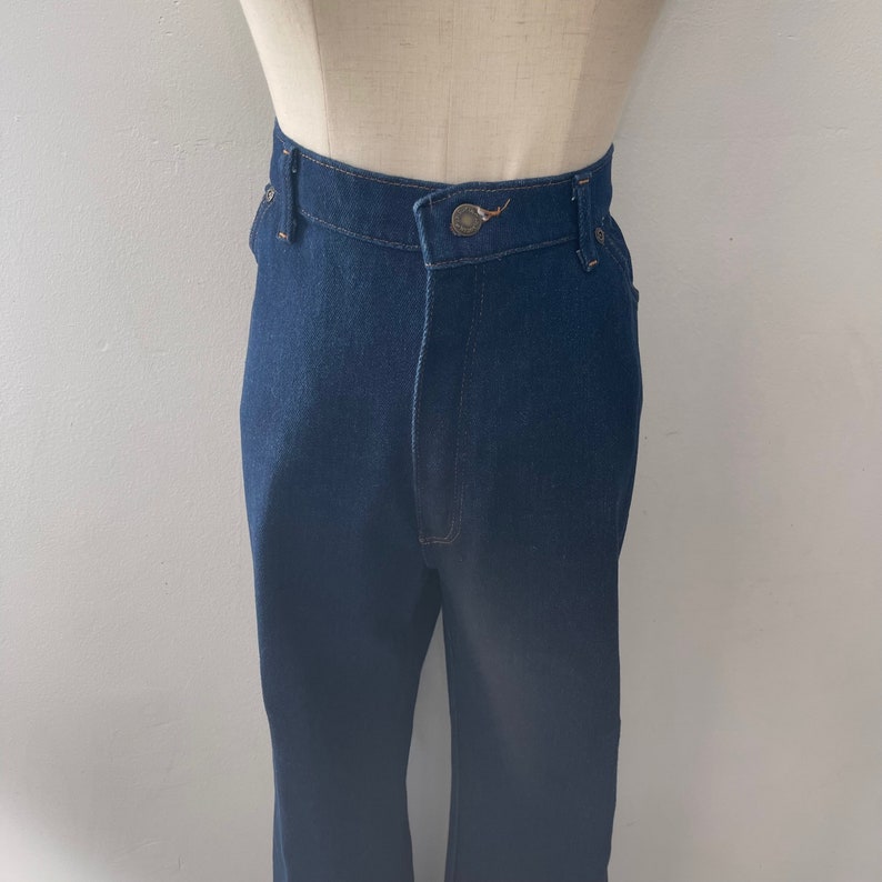 May include: A pair of dark blue denim jeans with a high waist and a straight leg.