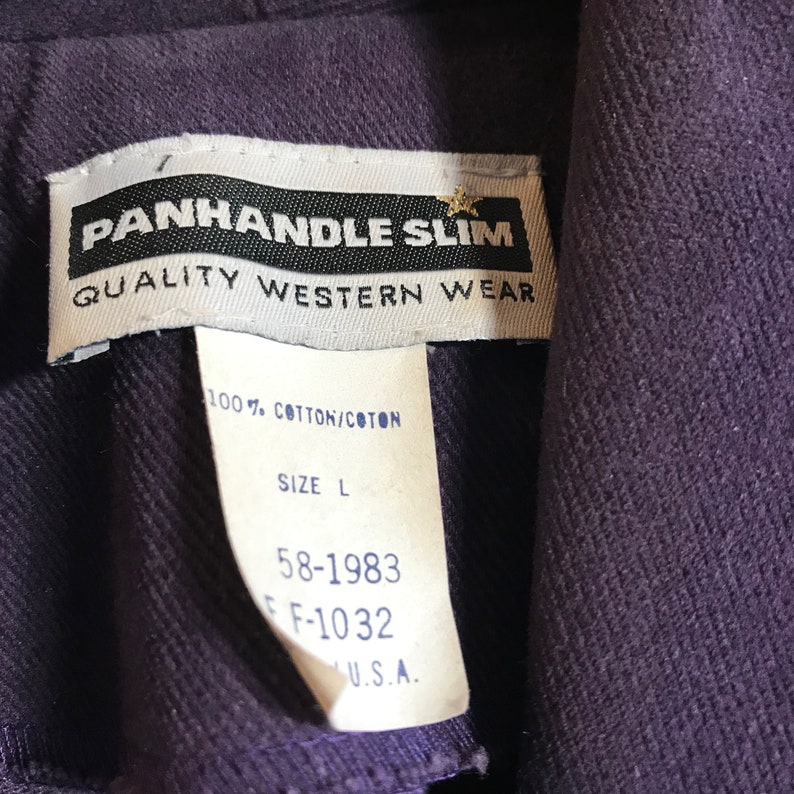 May include: A purple Western wear shirt with a white tag that reads "PANHANDLE SLIM QUALITY WESTERN WEAR 100% COTTON/COTON SIZE L 58-1983 F-1032 U.S.A."