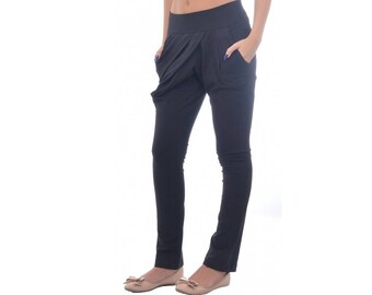 Puede incluir: Pantalón negro con un diseño único que presenta un frente fruncido y bolsillos grandes. El pantalón está hecho de una tela suave y elástica.