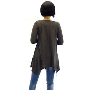 Peut inclure: Une tunique &agrave; manches longues de couleur gris anthracite avec une ourlet l&eacute;g&egrave;rement asym&eacute;trique. Le haut est fait d'un tissu doux et confortable et a une coupe d&eacute;contract&eacute;e.