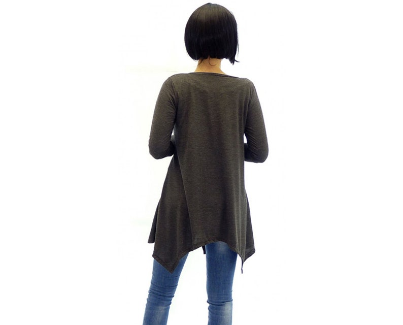 Peut inclure: Une tunique &agrave; manches longues de couleur gris anthracite avec une ourlet l&eacute;g&egrave;rement asym&eacute;trique. Le haut est fait d'un tissu doux et confortable et a une coupe d&eacute;contract&eacute;e.