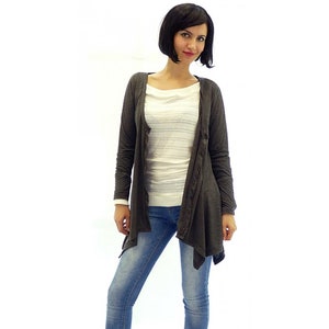 Peut inclure: Un cardigan gris fonc&eacute; &agrave; manches longues avec un ourlet asym&eacute;trique drap&eacute;. Le cardigan est fait d'un tissu doux et l&eacute;ger et a une coupe d&eacute;contract&eacute;e.