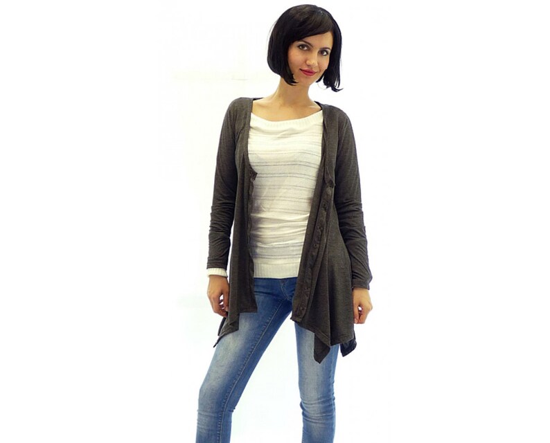 Peut inclure: Un cardigan gris fonc&eacute; &agrave; manches longues avec un ourlet asym&eacute;trique drap&eacute;. Le cardigan est fait d'un tissu doux et l&eacute;ger et a une coupe d&eacute;contract&eacute;e.