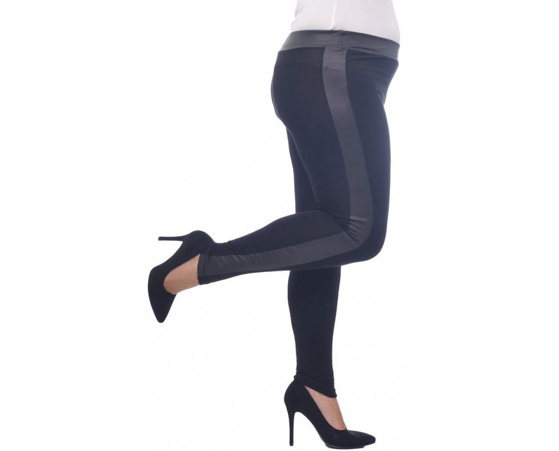 May include: Black leggings with a gray stripe down the side. The leggings are worn by a person with one leg raised and wearing black high heels.