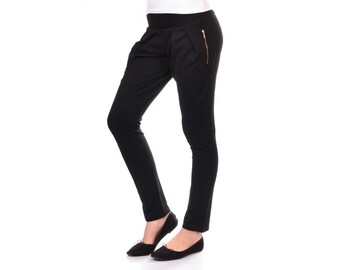 May include: Black pants with a gold zipper detail. The pants have a high waist and a slim fit.