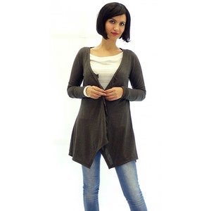 Peut inclure: Un cardigan gris anthracite &agrave; manches longues avec une ourlet asym&eacute;trique drap&eacute;. Le cardigan est ouvert &agrave; l'avant et se ferme par un bouton.