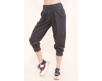 Puede incluir: Pantalón negro corto con cintura ancha y corte holgado y cómodo. El pantalón está hecho de una tela suave y elástica y tiene un aspecto informal y relajado.