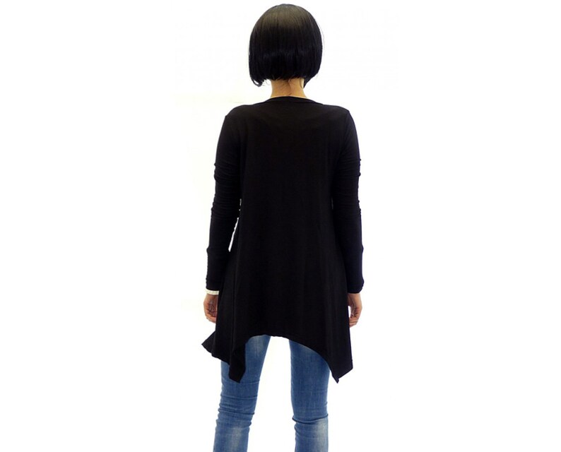 Peut inclure: Chemise noire &agrave; manches longues avec une ourlet asym&eacute;trique. La chemise est faite d'un tissu doux et extensible et a une coupe d&eacute;contract&eacute;e.