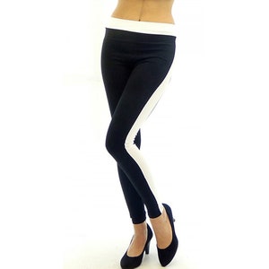 May include: Black leggings with a white stripe down the side. The leggings are made of a stretchy material and have a waistband.