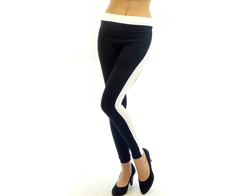 May include: Black leggings with a white stripe down the side. The leggings are made of a stretchy material and have a waistband.