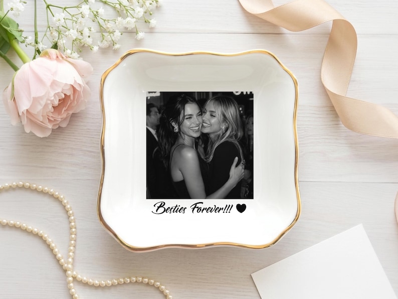 May include: A square white ceramic trinket dish with scalloped edges and a gold-painted rim. The center features a black and white photograph of two people embracing, with the text "Besties Forever!!!" and a black heart icon printed below.