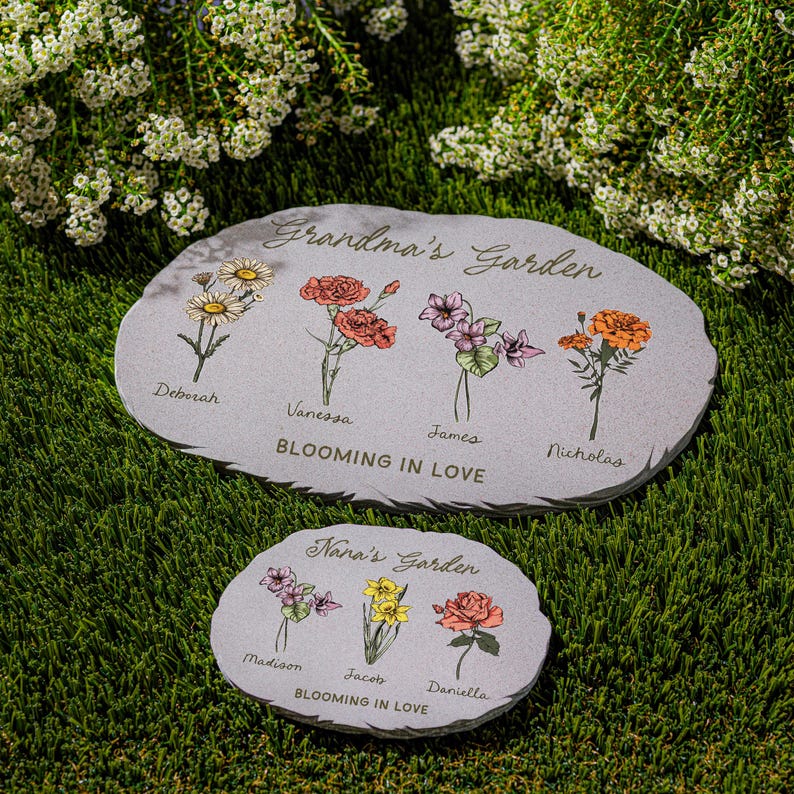 May include: Two gray stone garden markers with floral illustrations and the text "Grandma's Garden" and "Nana's Garden". The larger marker has names Deborah, Vanessa, James, and Nicholas. The smaller marker has names Madison, Jacob, and Daniella.