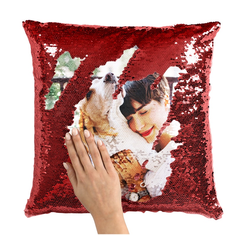May include: Red sequin pillow with a photo of a person holding a dog. The photo is visible through a hole in the sequins.