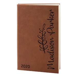 May include: Brown leather-bound journal with the year 2020 and the name "Madison Parker" engraved on the front cover.