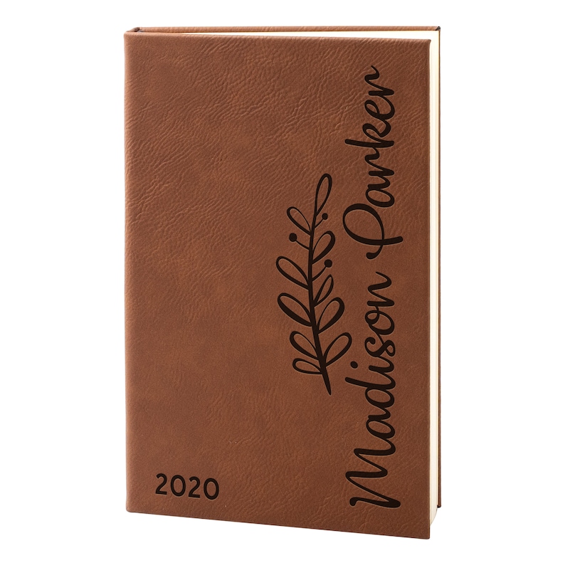 May include: Brown leather-bound journal with the year 2020 and the name "Madison Parker" engraved on the front cover.