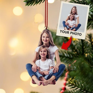 May include: A Christmas ornament featuring a photo of two girls sitting together. The ornament is made of wood and has a red string for hanging. The text "YOUR PHOTO" is printed on the ornament.