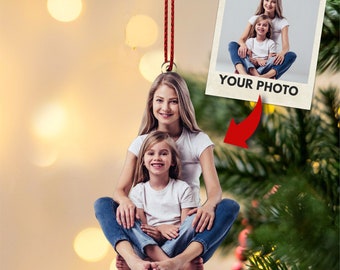 May include: A Christmas ornament featuring a photo of two girls sitting together. The ornament is made of wood and has a red string for hanging. The text "YOUR PHOTO" is printed on the ornament.