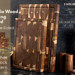 May include: Acacia wood cutting boards with a butcher block pattern. The double-sided boards are available in two sizes: large (45.7cm x 30.5cm) and medium (35.6cm x 24.1cm). The boards are brown and tan.