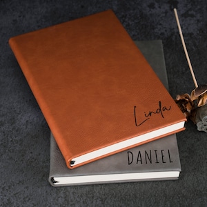 May include: Two brown leather journals with the names "Linda" and "Daniel" embossed on the covers.
