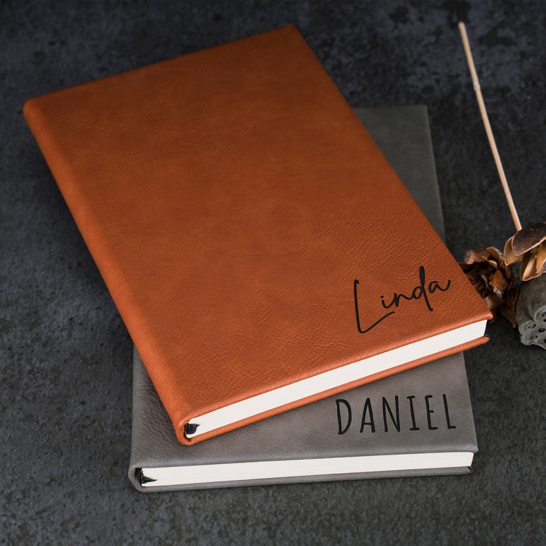 May include: Two brown leather journals with the names "Linda" and "Daniel" embossed on the covers.