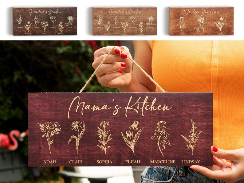 Puede incluir: Un letrero de madera con el texto "Mama's Kitchen" en escritura cursiva. El letrero est&aacute; decorado con seis ilustraciones de flores doradas y los nombres Noah, Clair, Sophia, Elijah, Marceline y Lindsay.
