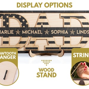 May include: Wooden sign with the word "DAD" in large letters, with an American flag design. The sign has a black background with a white stripe and a black stripe. The sign also has the names "Charlie", "Michael", "Sophia", and "Lindsay" written on it. The sign is shown with three different display options: a sawtooth hanger, a wood stand, and a string.